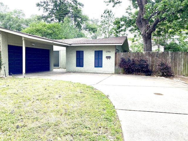 ranch-style home featuring a garage and a front lawn