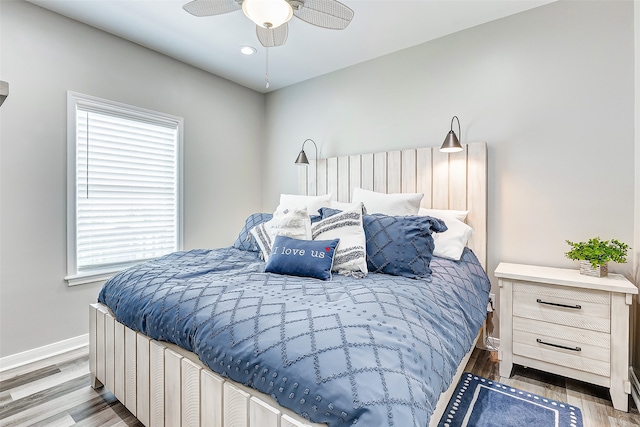 bedroom with ceiling fan, multiple windows, and wood-type flooring