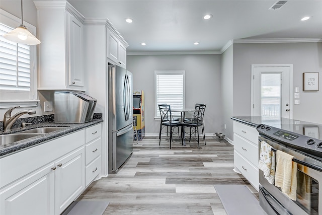 kitchen with light hardwood / wood-style floors, hanging light fixtures, stove, stainless steel fridge, and white cabinets