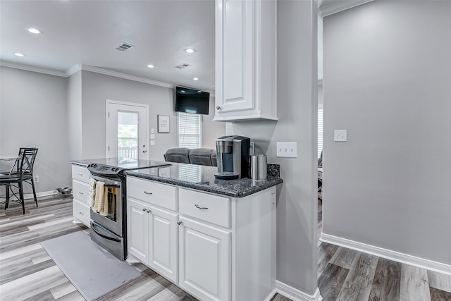 kitchen with dark stone countertops, white cabinets, electric range, and light wood-type flooring