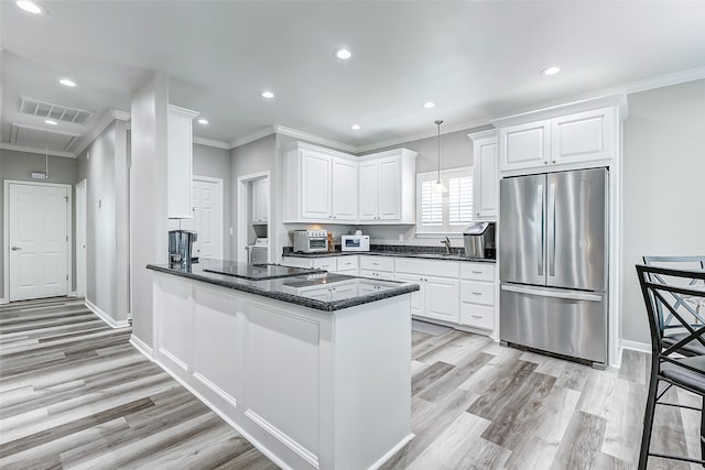 kitchen featuring light hardwood / wood-style flooring, kitchen peninsula, stainless steel fridge, hanging light fixtures, and white cabinetry