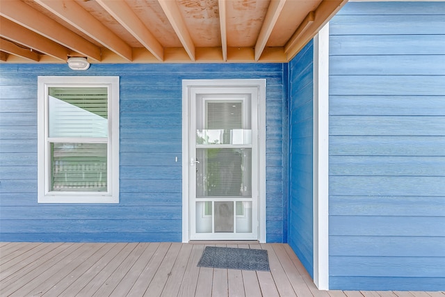 view of exterior entry with a wooden deck