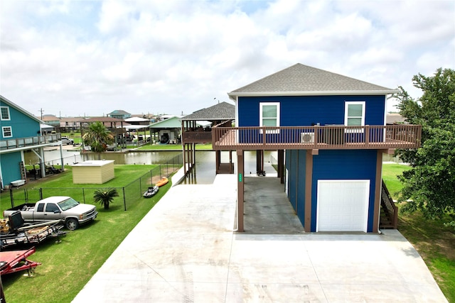 view of front of house with a garage, a front yard, a balcony, and a water view