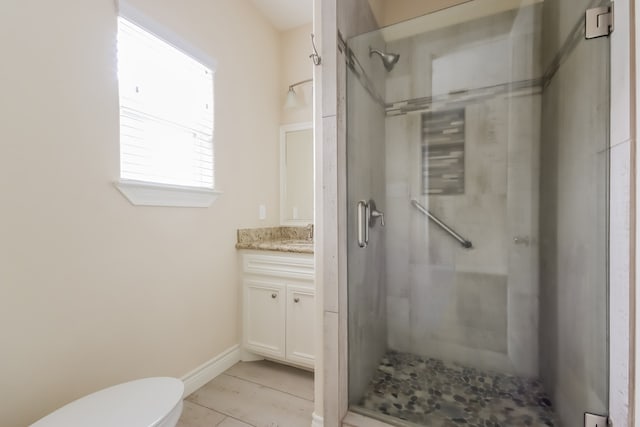 bathroom featuring tile floors, tiled shower, toilet, and vanity