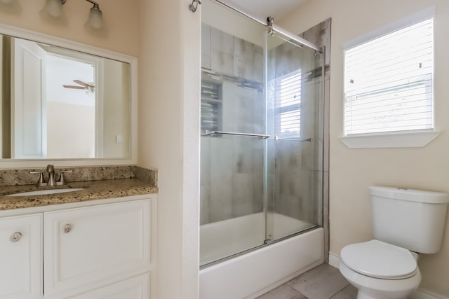 full bathroom featuring combined bath / shower with glass door, ceiling fan, toilet, tile flooring, and vanity