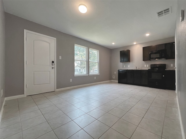 unfurnished living room featuring light tile patterned flooring and sink