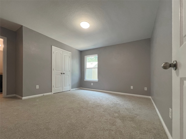 carpeted spare room with a textured ceiling