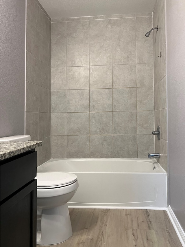 full bathroom with toilet, hardwood / wood-style floors, vanity, and tiled shower / bath