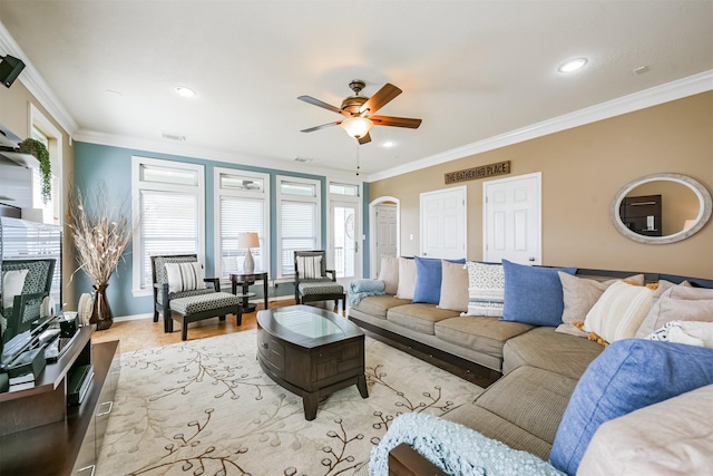 living room featuring light hardwood / wood-style floors, ceiling fan, crown molding, and a healthy amount of sunlight