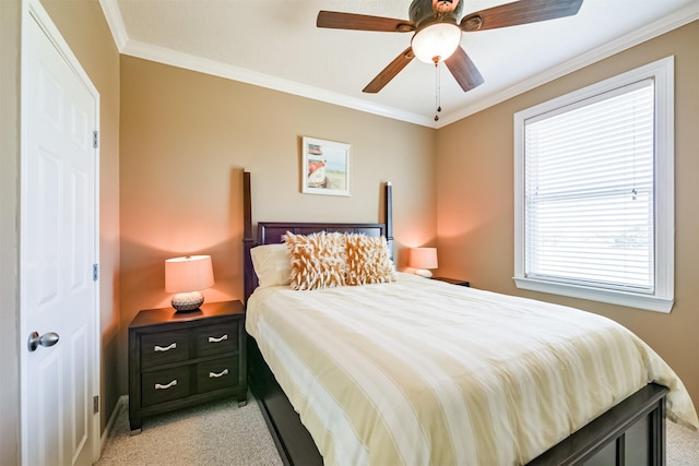 carpeted bedroom with a closet, ceiling fan, and crown molding