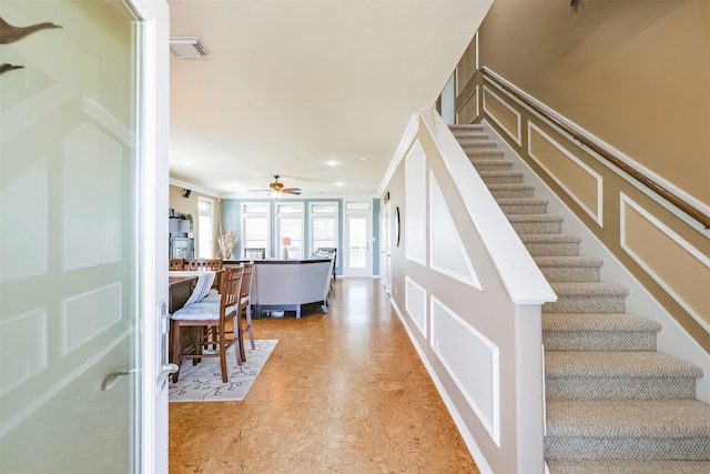 stairway featuring ornamental molding and ceiling fan