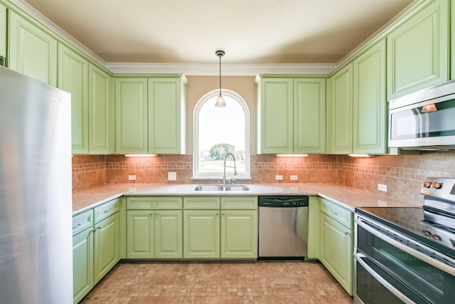 kitchen featuring appliances with stainless steel finishes, hanging light fixtures, green cabinetry, sink, and tasteful backsplash