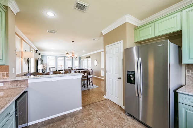 kitchen featuring beverage cooler, stainless steel fridge with ice dispenser, light stone countertops, ornamental molding, and a notable chandelier