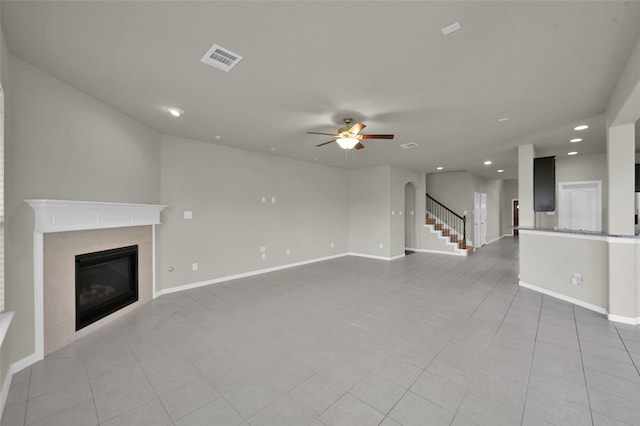 unfurnished living room with light tile floors, ceiling fan, and a fireplace