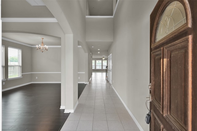 foyer with a notable chandelier, hardwood / wood-style flooring, and crown molding