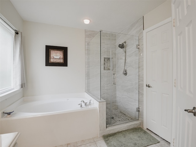 bathroom with independent shower and bath, a wealth of natural light, and tile patterned flooring