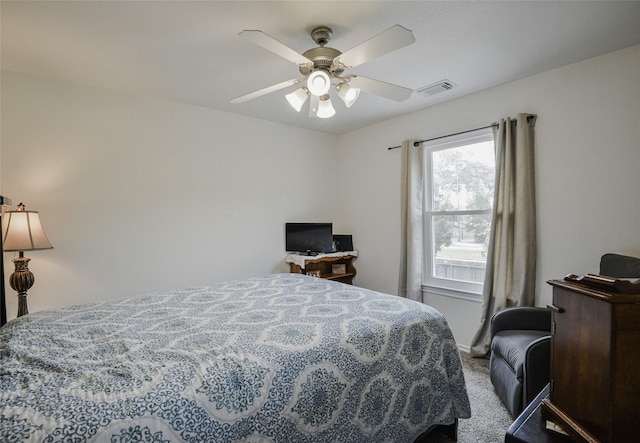 carpeted bedroom featuring a ceiling fan and visible vents