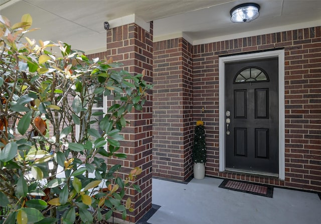 doorway to property featuring brick siding