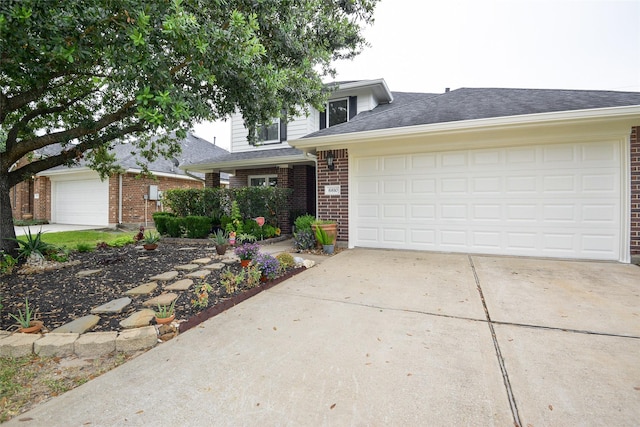 traditional-style home featuring brick siding, driveway, a shingled roof, and a garage