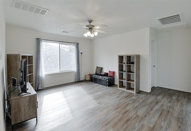 interior space with ceiling fan, visible vents, and wood finished floors