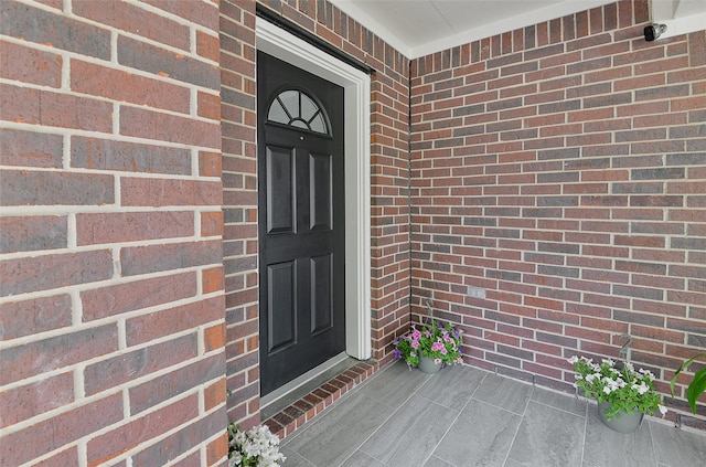 property entrance featuring brick siding