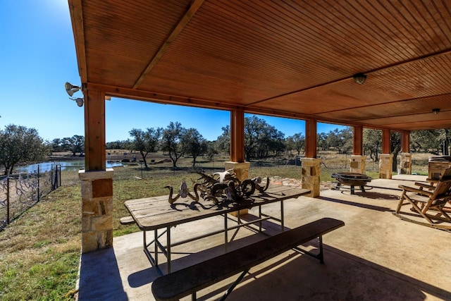 view of patio with a water view and an outdoor fire pit