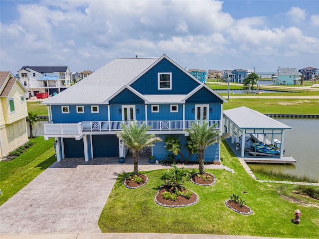 view of front of house with a garage, a front lawn, and covered porch