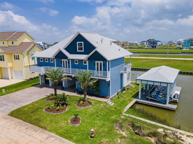 view of front facade with a dock, a front yard, covered porch, and a water view