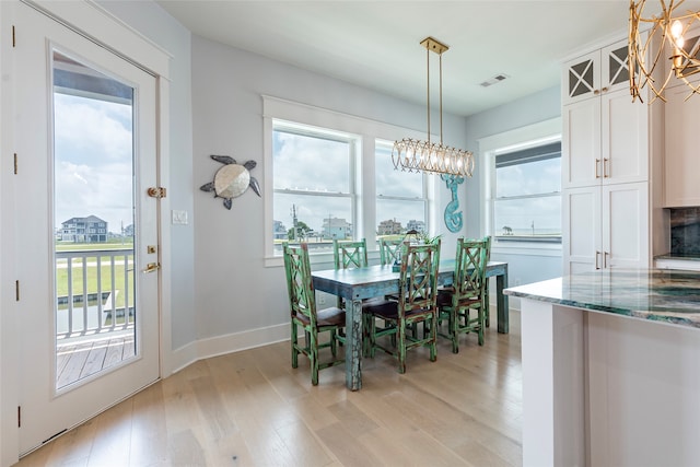 dining room with light wood-type flooring and a healthy amount of sunlight