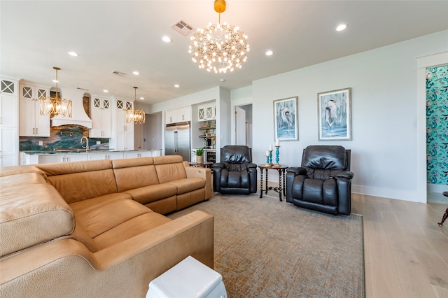 living room featuring recessed lighting, visible vents, and an inviting chandelier