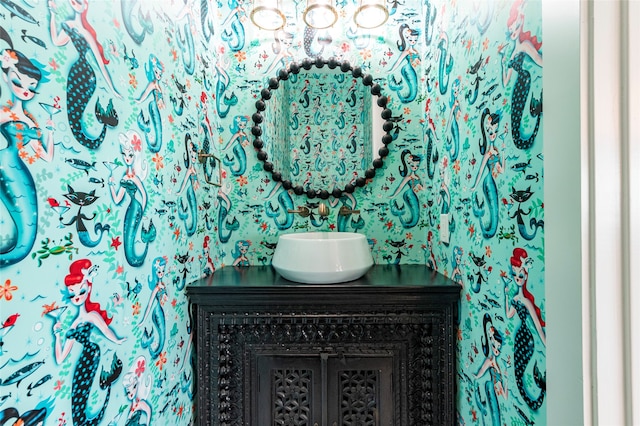 bathroom with vanity and wallpapered walls