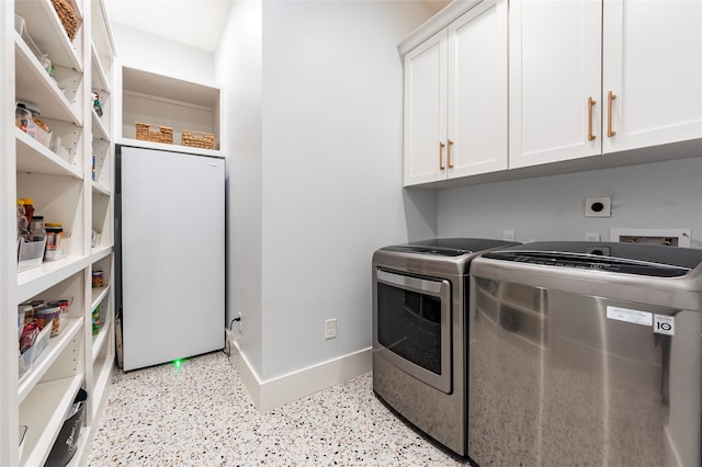 laundry room featuring washing machine and dryer and cabinets