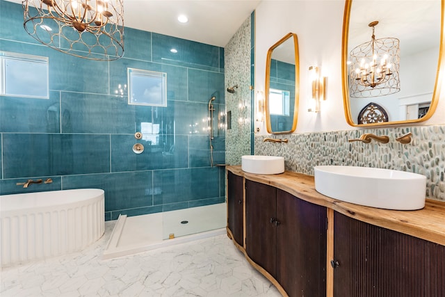 bathroom featuring tile walls, tiled shower, vanity, and a chandelier