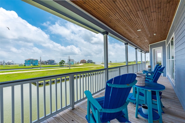 wooden deck with a water view and a yard