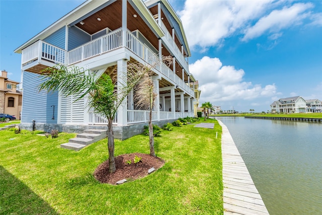 exterior space with a water view, a yard, and a balcony