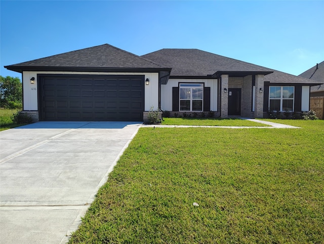 view of front of property featuring a garage and a front lawn