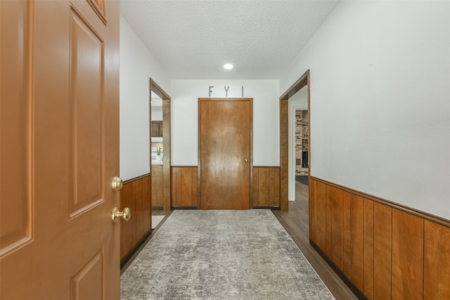 hallway featuring dark hardwood / wood-style floors and a textured ceiling