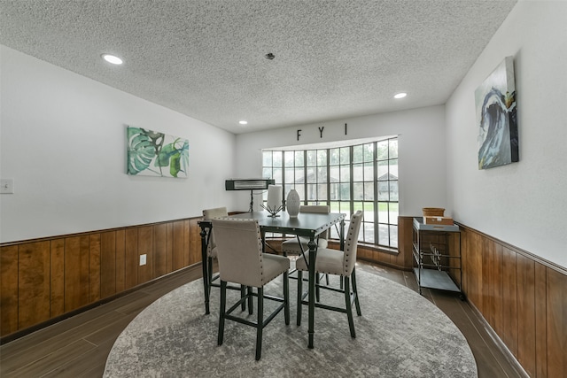 dining space featuring a textured ceiling and dark wood-type flooring