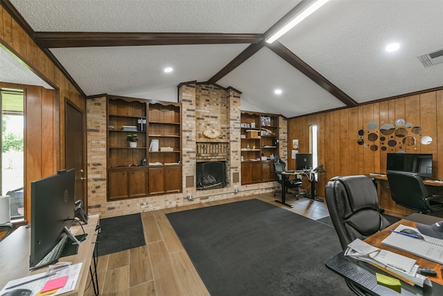 office area with a brick fireplace, wooden walls, and a textured ceiling