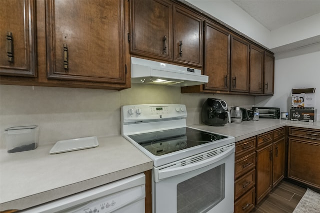 kitchen featuring dark brown cabinetry and white appliances