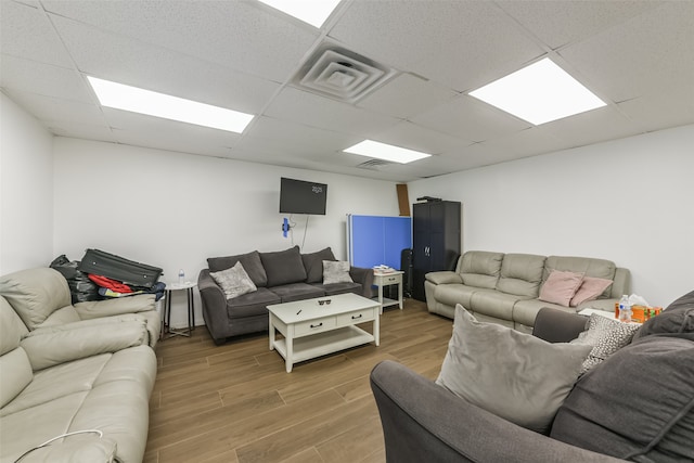 living room with hardwood / wood-style flooring and a drop ceiling