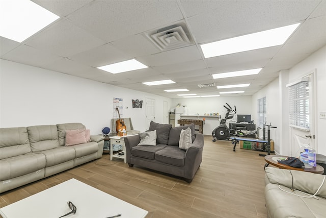 living room featuring wood-type flooring and a paneled ceiling