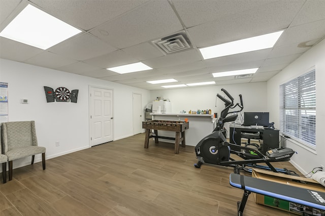 workout area featuring a paneled ceiling and wood-type flooring