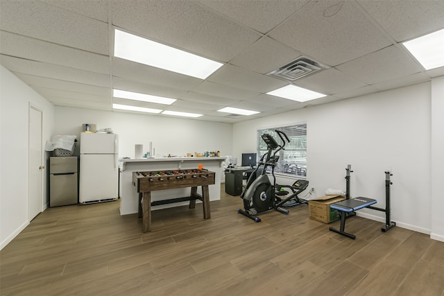 workout room with hardwood / wood-style flooring and a drop ceiling