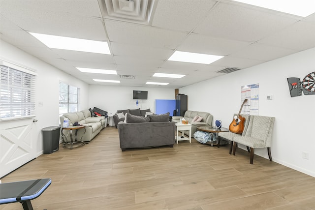 living room featuring light hardwood / wood-style floors and a drop ceiling