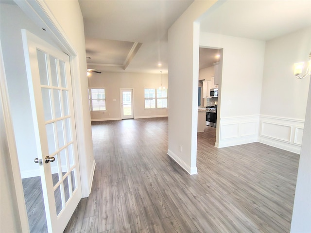 interior space featuring a wainscoted wall, a decorative wall, and wood finished floors