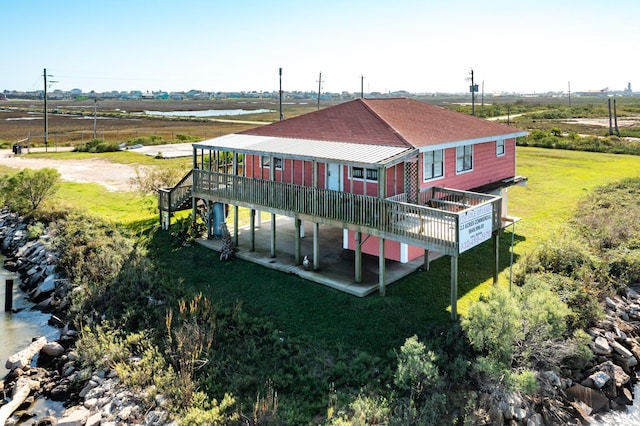 rear view of house featuring a yard and a deck