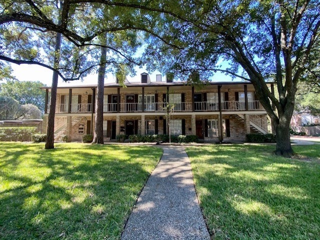 multi unit property featuring stairs and a front yard