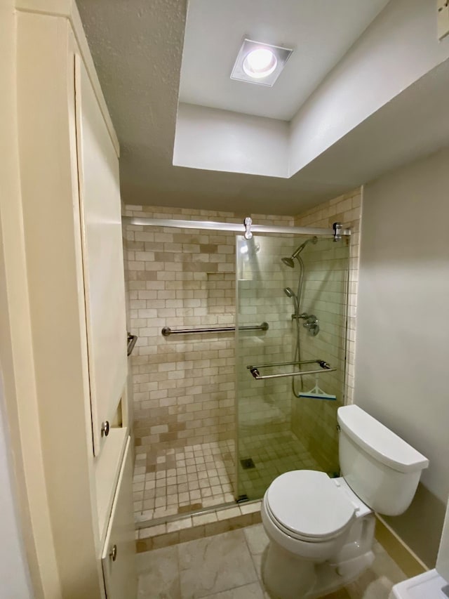 bathroom with an enclosed shower and toilet