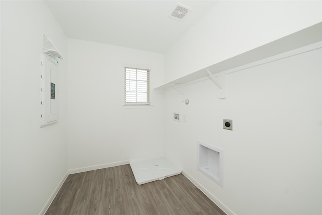 clothes washing area with hookup for an electric dryer, washer hookup, gas dryer hookup, wood-type flooring, and electric panel